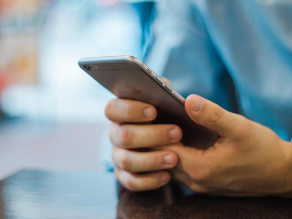 A parent’s hands holding a phone