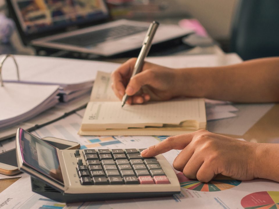 Hands working through paperwork with a calculator